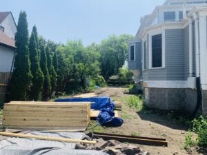 The narrow side yard of a stately Neo-Georgian home in the Kenwood neighborhood of Minneapolis, has been stripped of turf and shows signs of continued construction.