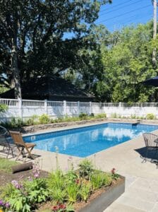 On a summer day in the Kenwood neighborhood of Minneapolis, an in-ground pool, surrounded by brightly colored cottage-style planting beds, glistens in the sun.